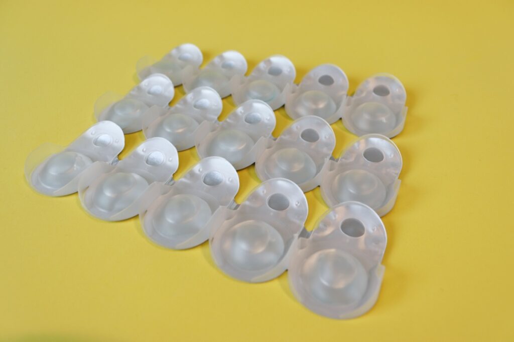 Contact lens blister packs arranged together on a yellow background.